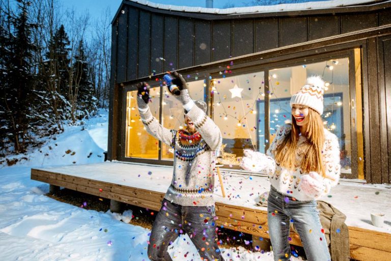 Un chalet en bois décoré pour Noël, entouré de neige et de sapins