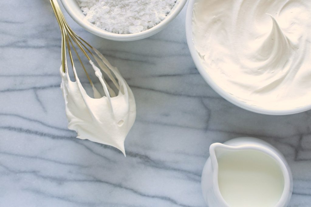Une batteuse avec de la crème dans un bol sur la table