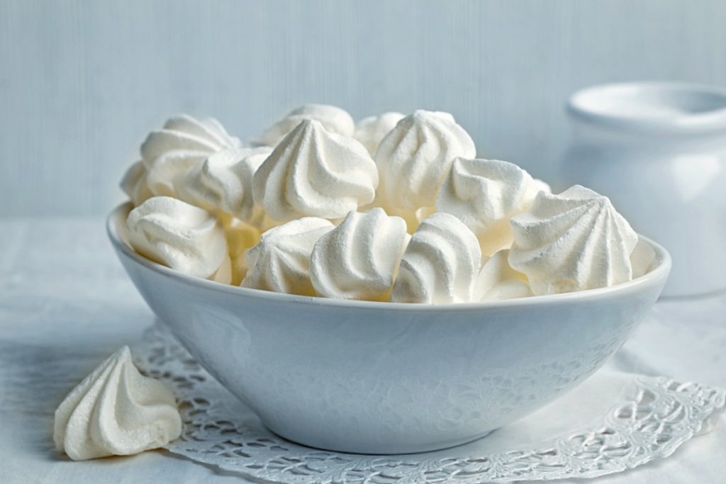 Un bol plein de méringues blanches sur la table