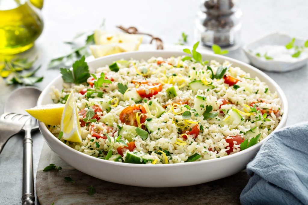 Un bol de salade de riz avec du concombre et de tomate