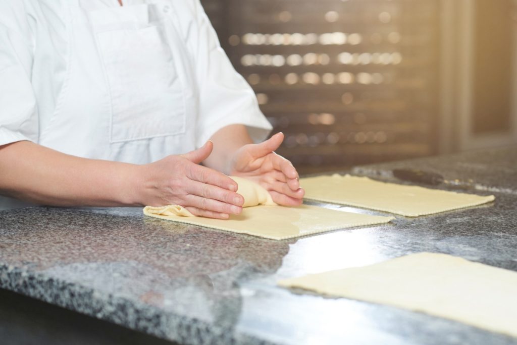Un chef préparant de la pâte feuilletée dans la cuisine