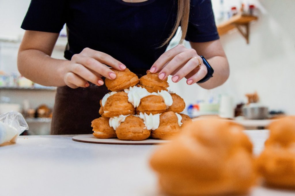 Mains d'une femme faisant de la pièce montée en choux