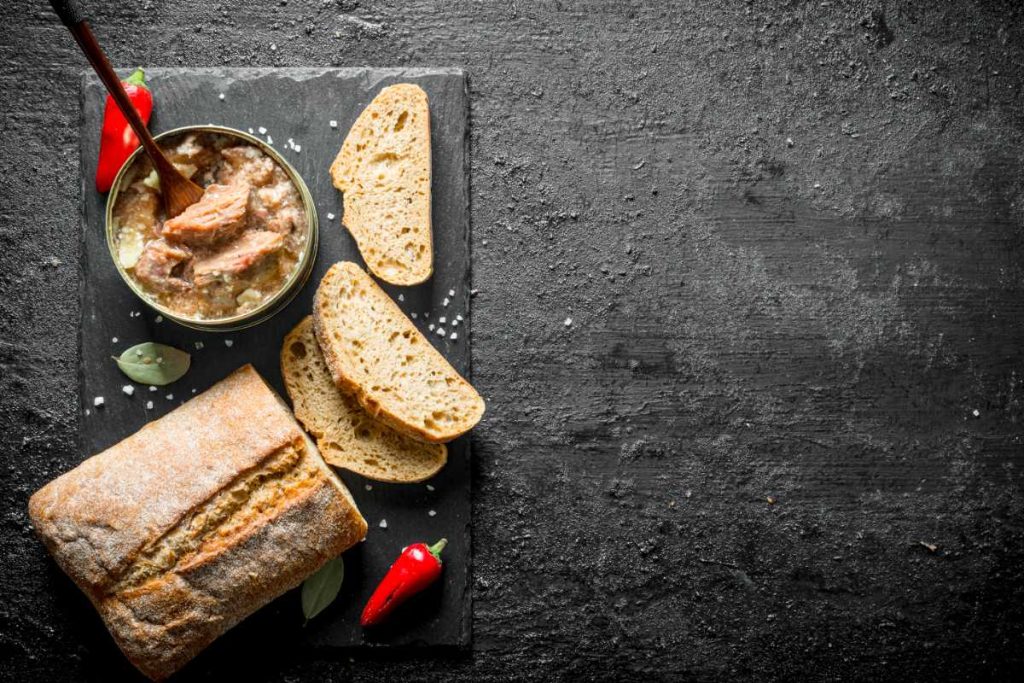 Paté au piment d'espelette avec du pain et des piment sur la table