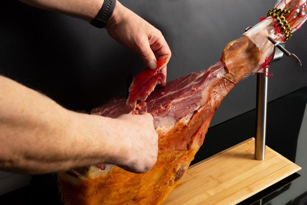Une personne préparant du jambon