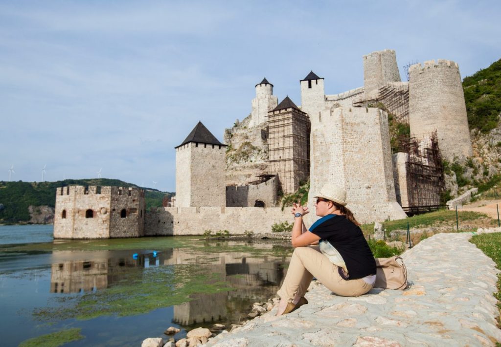 Une touriste assise près d'un château