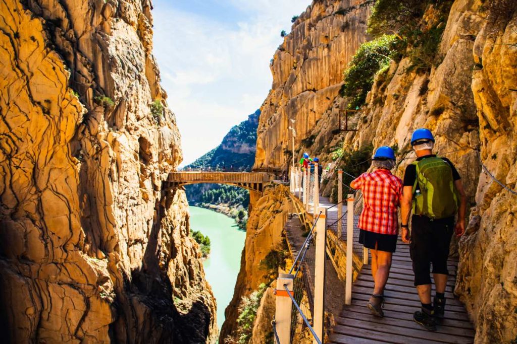 Des visiteurs marchant sur un pont en bois au milieu des rochers